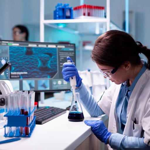 Chemistry doctor in engineering virus with mciropiette Chemistry doctor in engineering virus with mciropiette medicine dropper. Woman research a new experiment in modern lab, analyzing pharmaceutical work with modern equipment.